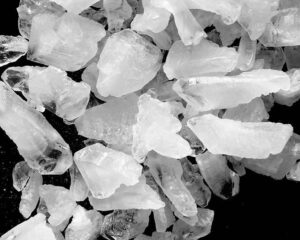 Ammonium alum crystal blocks in assorted sizes on a black background.