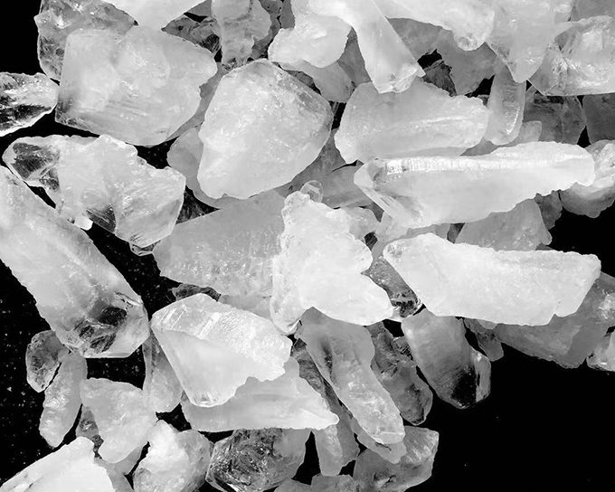 Ammonium alum crystal blocks in assorted sizes on a black background.